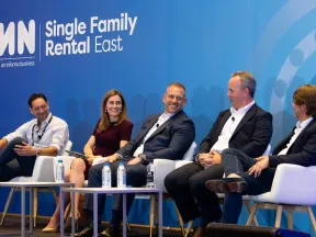 Five panelists engaged in discussion at the IMN Single Family Rental East conference stage with branded backdrop.