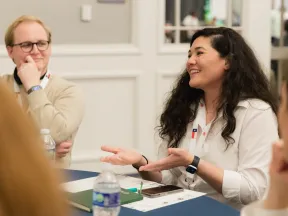 Two professionals engaged in a friendly meeting or discussion around a conference table indoors.