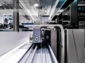 Close-up of an industrial linear rail system used in precision machinery with metal screws and tracks.