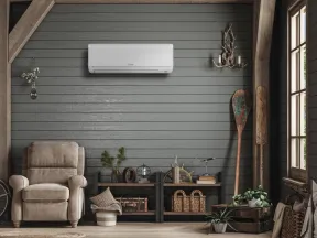 Cozy living room with a beige armchair, wooden decor, air conditioner, and rustic gray shiplap walls.