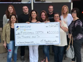 Group of people holding a $1000 donation check to Massapequa SEPTA outside Brokerage Entertainment venue