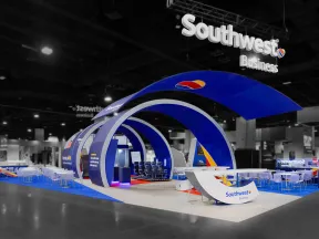 Modern Southwest Business exhibition booth with blue arches, seating, and branded signage at trade show.