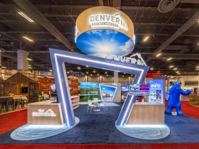 Modern Denver tourism booth with illuminated geometric entrance and promotional displays at convention center