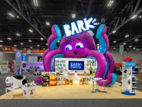 Colorful trade show booth with giant purple octopus, BARK logo, and dog products on display.
