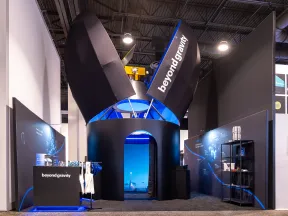 Modern Beyond Gravity exhibit booth with black and blue design elements at a trade show.