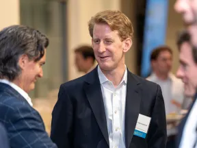 Business professionals networking and conversing at a corporate event in formal attire with name tags visible