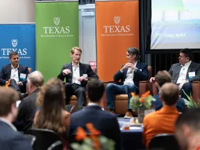 Panel discussion at The University of Texas at Austin event with four speakers and audience engagement