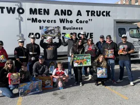 a group of people posing for a photo in front of a truck