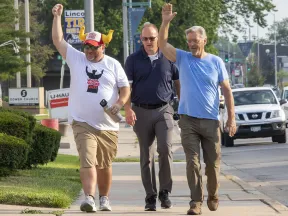 a group of men walking on the sidewalk