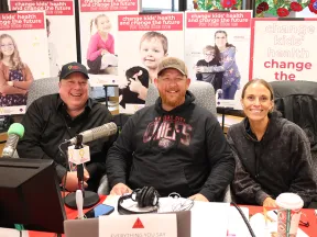 Pat Phelan et al. sitting at a table with microphones