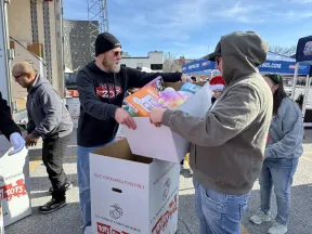 a person handing a box to another man