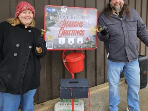 a man and woman standing next to a sign