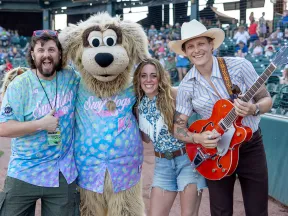a group of people posing with a person in a garment