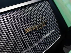 Close-up of a car grille with a distinctive 911S badge on a honeycomb pattern mesh.