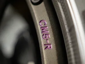 Close-up of a metallic surface with engraved purple text reading CM5-R on a textured background.