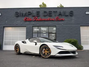 White luxury sports car with bronze rims parked outside Simple Details Elite Automotive Care building.