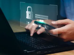 Person using smartphone and laptop with digital security login screen and padlock icon overlay.
