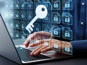 Person typing on laptop with digital key and locked file icons representing cybersecurity and data protection.