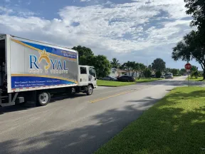 Royal Pest & Termite service truck parked on a sunny suburban street with houses and greenery.