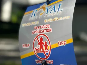 Royal Pest & Termite pesticide application warning sign advising to keep off treated area outdoors.