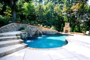 An outdoor living space with a gunite pool, spillover spa, water features, and outdoor fireplace.