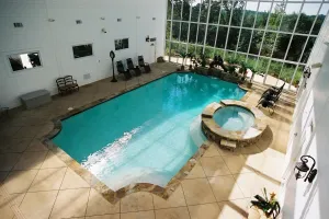 Indoor gunite pool with spillover spa.