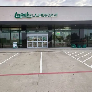 Exterior view of Lapels Laundromat with empty parking spaces and visible storefront signage.