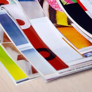 A stack of open magazines with Aqueous Coating applied to the pages