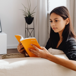 A young woman reading a Perfect Bound book