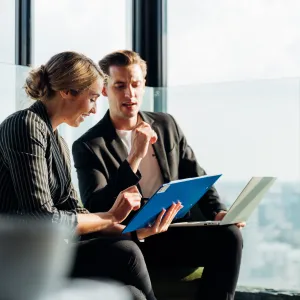 a man and a woman looking at a laptop