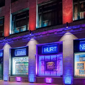 House of Blues building lit with purple and blue lights with overlaid text reading HELP EVER HURT NEVER