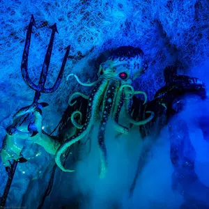 Cthulhu figure with glowing red eyes holding a trident amidst blue fog and web-like textures underwater.