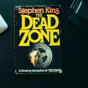 Stephen King’s novel The Dead Zone with overlaid title text in yellow on a black book cover.