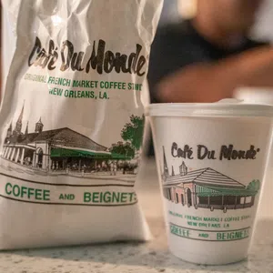 Cafe Du Monde coffee cup and bag featuring French Market coffee shop branding from New Orleans, Louisiana.