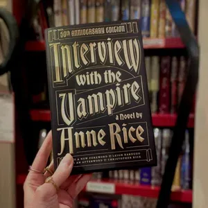 Hand holding the 50th Anniversary Edition of Interview with the Vampire by Anne Rice with overlaid text on the book cover.