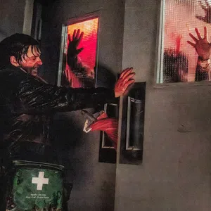 Man pushes hospital doors with bloody hands as silhouettes press against red-lit windows in a tense scene.