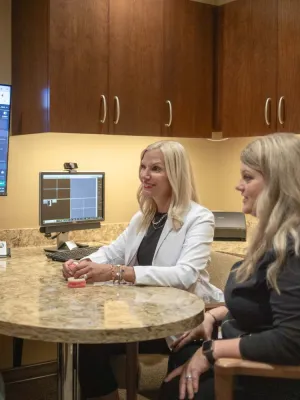 Dentist consulting with patient using dental imaging technology displayed on screen in modern office.