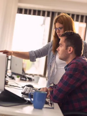 a man and a woman looking at a computer screen