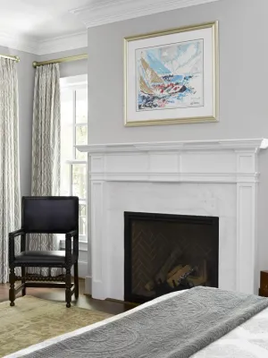 a room with a fireplace and chairs