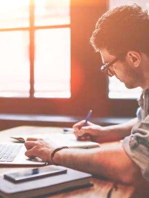 a man writing on a laptop