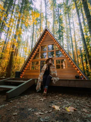 a person sitting on a bench in front of a log cabin