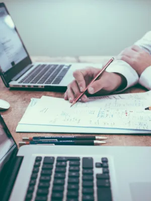 a person sitting at a table using a laptop computer