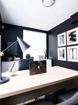 a desk with a lamp and a window with a plant on it