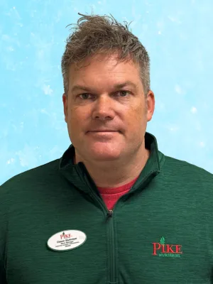 Man wearing green Pike Nurseries jacket with name tag against a light blue background.