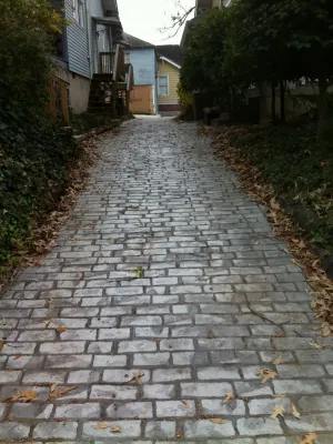 a cobblestone road with houses on either side of it