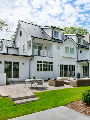 a large white house with a lawn and a table in front