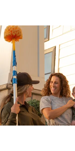 a Ridd technician holding a cob web duster talking to customer