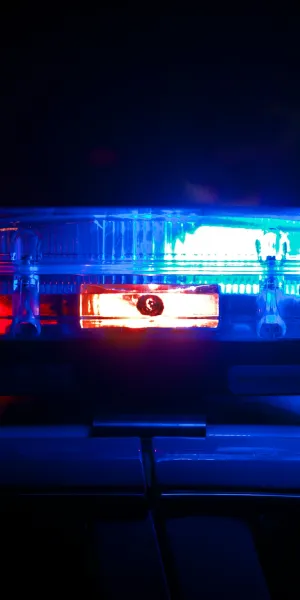 Close-up of red and blue flashing police car emergency lights at night on the roof of a vehicle
