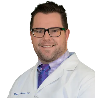 a man wearing glasses posing for the camera