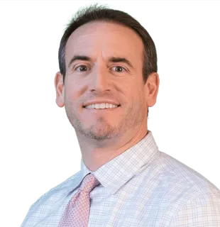 a man wearing a striped shirt and looking at the camera